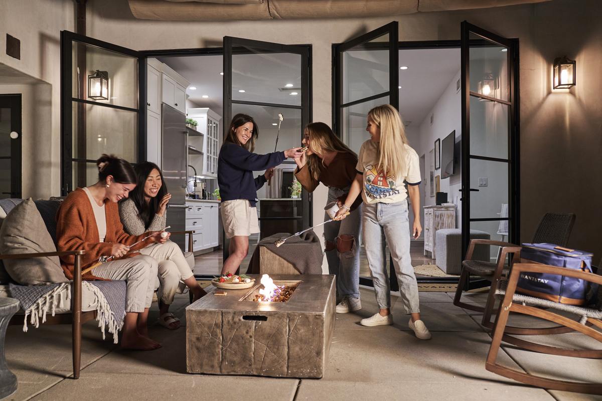 AvantStay guests gathering around an outdoor firepit