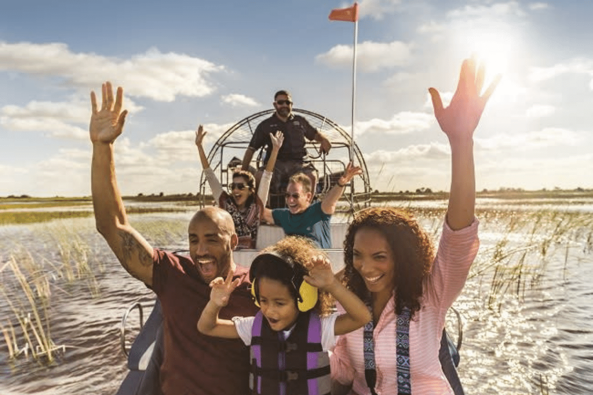 family in a flat-bottomed boat. seeing alligators is a popular thing to do in fort lauderdale