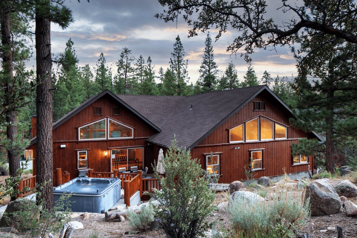 Bernard by AvantStay. Home exterior with an outdoor hot tub, surrounded by pine trees.