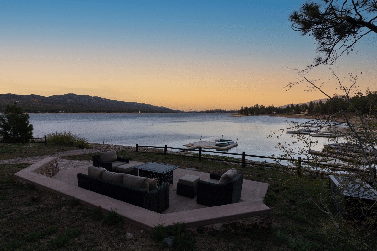 Shoreline Lakehouse by AvantStay. A large open deck with outdoor couches and furniture sits with a private dock on Big Bear Lake.
