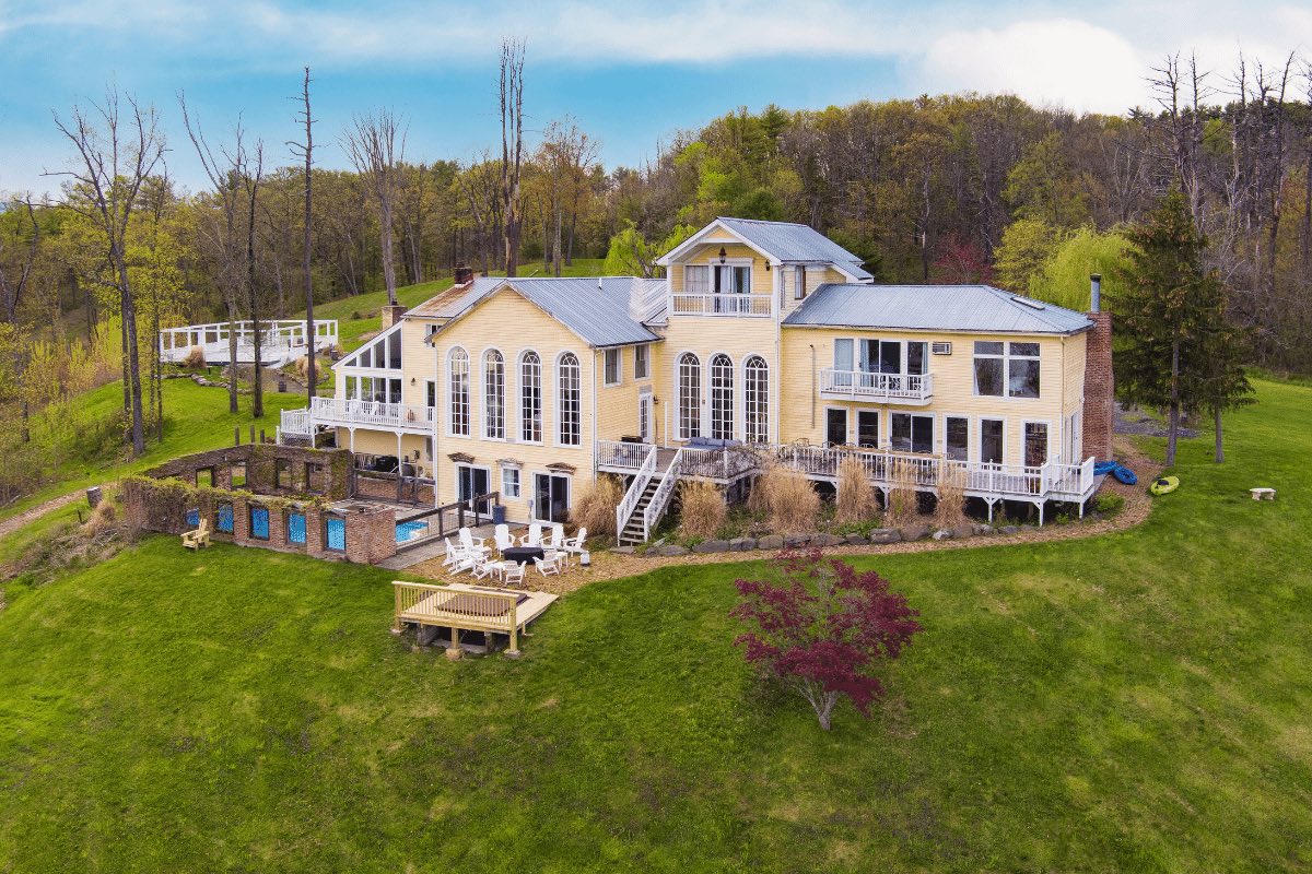 Shakespeare on the Hudson by AvantStay. The large home exterior rear showcasing a gated pool, balcony, patio, and spacious yard.
