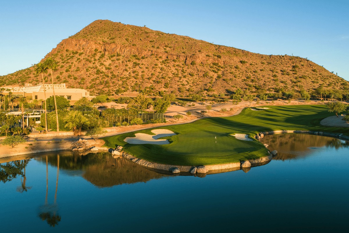 The Phoenician scenic golf course in Scottsdale surrounded by mountains and a reflection body of water