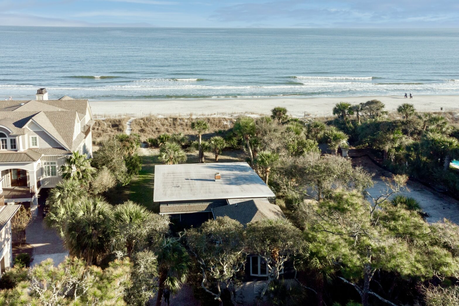 private beachfront house with green trees and serene beach waves