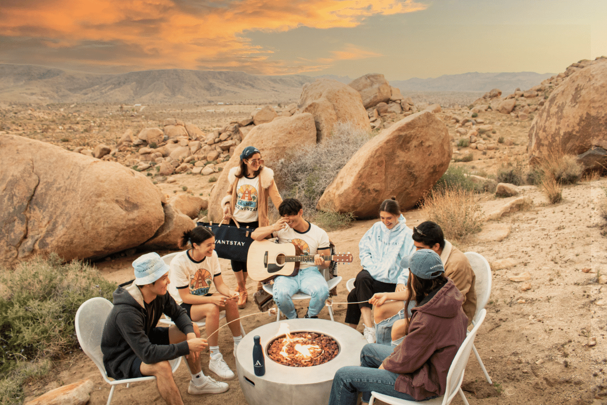 employees gathered around a campfire during their company offsite